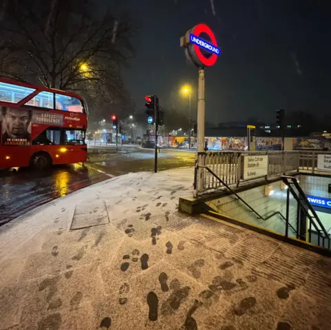 BBC Weather Watchers/Shahid A light dusting of snow shows footprints of commuters at Swiss Cottage Underground station in London