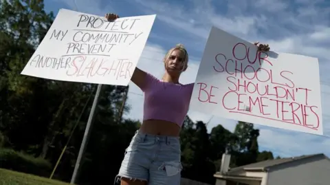 Reuters A pupil  holds signs protesting against schoolhouse  shootings