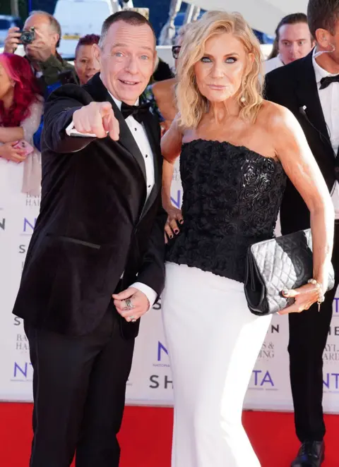 PA Mídia Adam Woodyatt e Michelle Collins