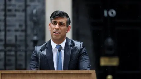 Reuters Rishi Sunak getting soaked in the rain at a pedestal in Downing Street as he announced a general election would take place on 4 July