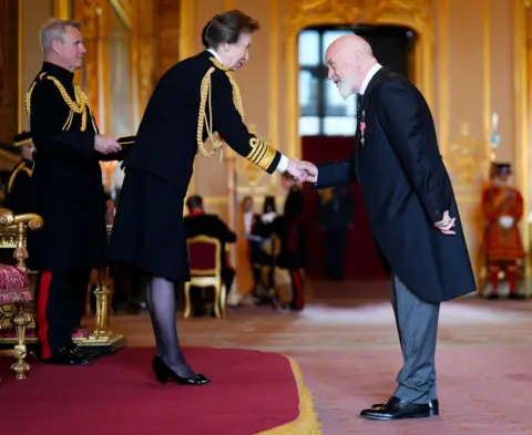 PA Media Bill Bailey shakes hands with the Princess Royal