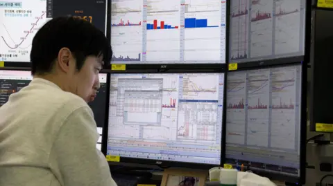 EPA A South Korean dealer works in front of monitors at the Hana Bank in Seoul