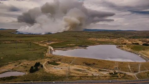 Stephen Davies / The Photoshop Guy Aerial view shows a huge swathe of moorland ablaze with a reservoir in the foreground
