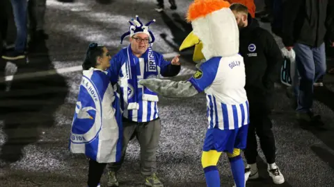Getty Images Albion fans with the Brighton mascot 