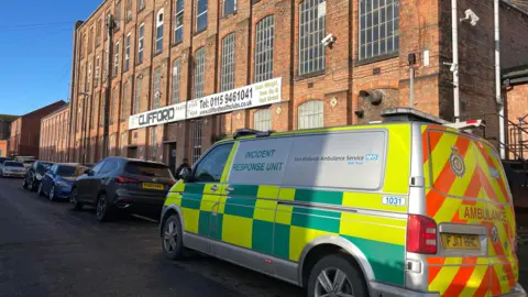 An Incident Response Unit van parked outside Clifford Health Club and Spa, a red brick building.