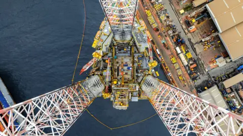 Offshore rig under construction in shipyard by the sea.