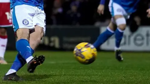 Pald Media Stock County County pode ser visto do tronco enquanto joga no campo. O cara antes de chutar o futebol.