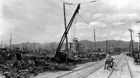 Pictures from History/Universal Images Group via Getty Images A Japanese man with a bicycle walks through the ruins of Hiroshima following the dropping of the world's first atomic bomb on the city on 6 August 1945