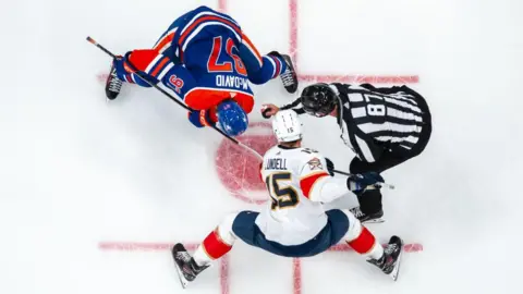 Getty Images Connor McDavid, 97, of the Edmonton Oilers takes a face-off against Anton Lundell #15 of the Florida Panthers in Game Six of the 2024 Stanley Cup Final at Rogers Place on June 21, 2024, in Edmonton, Alberta, Canada