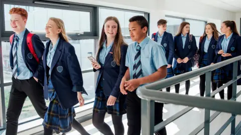 Getty Images A radical  of High schoolhouse  students walking to their adjacent  class. There is simply a premix  of 8  boys and girls and they deterioration  bluish  and tartan uniforms. 