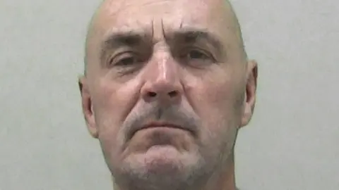 Northumbria Police Mugshot of Robert Tait. He is bald with very faint grey stubble.