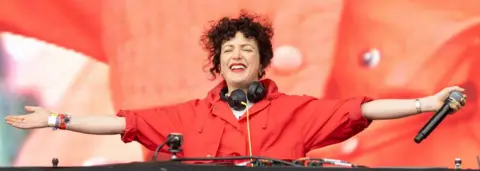 Getty Images Annie Mac smiling and with her arns outstretched on stage