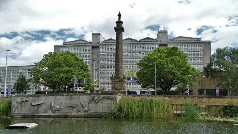 Neil Theasby / Geograph Hull College main building with the pond of Queens Gardens in the foreground and the column of the Wilberforce Monument in the middle 