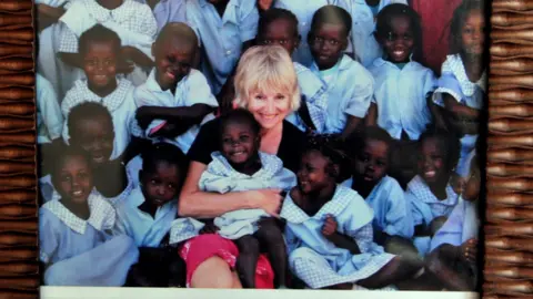 Paul Fry Organ donor Adrienne Fry is pictured cuddling school pupils in Gambia, wearing school uniform.