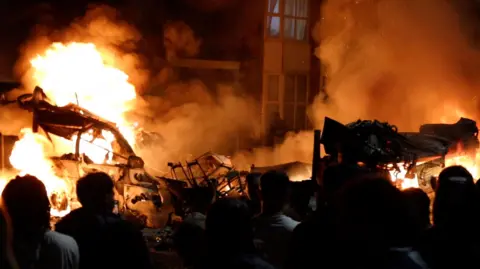 BBC Vehicles on fire during a riot