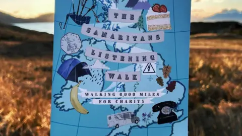 David Matthews The front cover of a book is held up to the camera. It shows a map of the UK and several objects including a banana, cake, telephone and a tent.