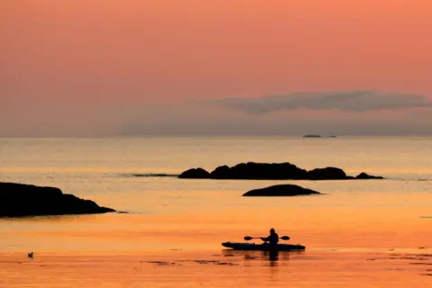 David Hughes Kayaker at sunset off Mull