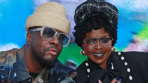 Wyclef Jean and Lauryn Hill leaning together and posing for the camera