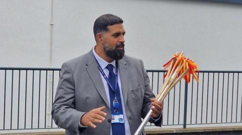 A teacher holding the torch replica