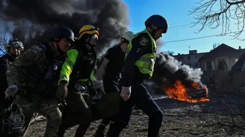 Reuters Emergency workers carry an injured woman at the site of a Russian missile strike in Zaporizhzhia in April