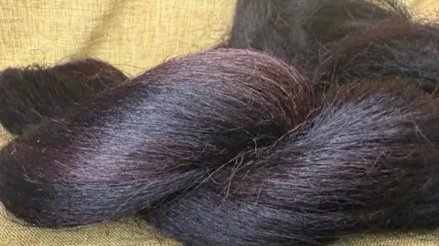 Jacqueline Shaw A close-up shot of banana tree bark braided hair. It is dark/light purple.