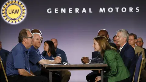 Getty Images General Motors CEO Mary Barra sitting across from leaders of the United Auto Workers union