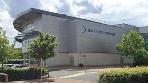 Google The outside of a modern building with 'Darlington College' written in blue on the side of the building.