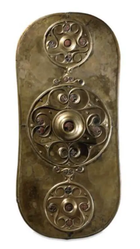 Trustees of the British Museum A bronze-coloured shield facing with engraved decorations