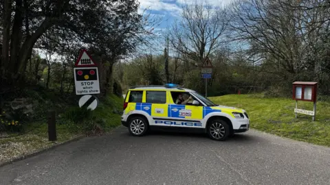 Dorset Police Police car parked across a road blocking access.