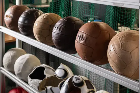 Loughborough University A line of leather footballs lined up on a rail