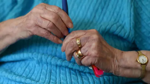 The hands of an elderly woman with rings on her fingers