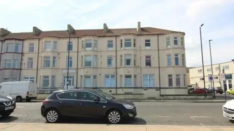 BBC Mulroy's is a three-storey white terraced seafront building.