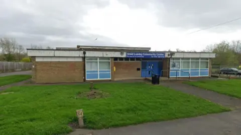 Google Great Lumley Community Cenytre. The paint peeling from the building. Mowed grass is in front of the building.