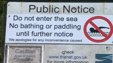 A sign warning people "Do not enter the sea, no bathing or paddling until further notice."