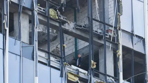 Reuters Members of Russia's security services investigate a damaged building following a drone attack in Moscow. Photo: 24 July 2023