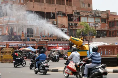 Getty Images A vehicle of the Jaipur Municipal Corporation Heritage is spraying water mist to provide relief from the scorching sun on a hot summer day, in Jaipur, Rajasthan, India, on May 15, 2024. (Photo by Vishal Bhatnagar/NurPhoto via Getty Images)