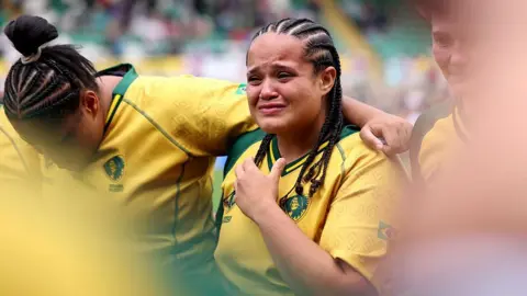 Getty Images A Brazilian rugby player in a yellow shirt. She is emotional and close to tears.