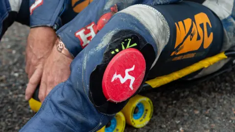 WDSC A close-up shot of a Manx flag logo embedded into a skater's leathers. 