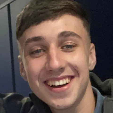 PA Jay Slater seen in a family handout photo. He has short brown hair and is smiling into the camera.