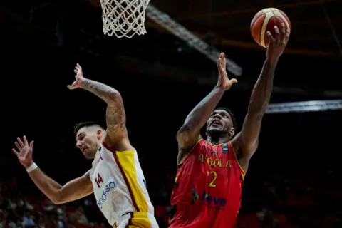 BORJA B HOJAS/GETTY IMAGES Angola's Silvio De Sousa and Spain's Willy Hernangomez vye for the shot  during an Olympic hoops  qualifier connected  Wednesday.