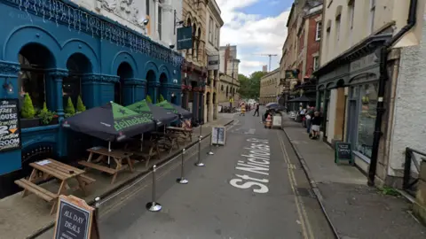 St Nicholas Street in Bristol. There are shops and restaurants lining the street.