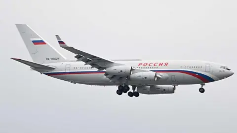 Anadolu via Getty Images A white plane with the legend Rossiya arrives in Alaska in August