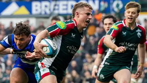 Billy Searle of Leicester Tigers scores a try during the Prem Rugby Cup semi-final against Bath at Mattioli Woods Welford Road Stadium. Various Bath players watch on in background