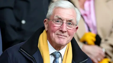 Getty Images John Richards wearing glasses and a yellow scarf 