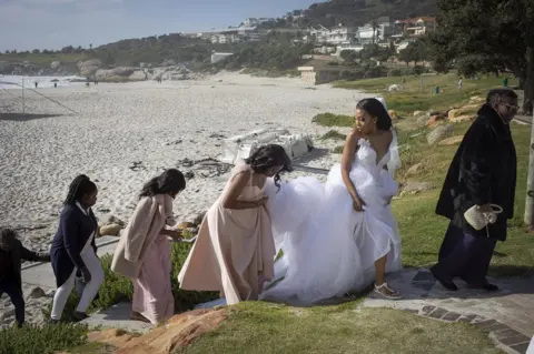 EPA A bridal party walks up from the beach.