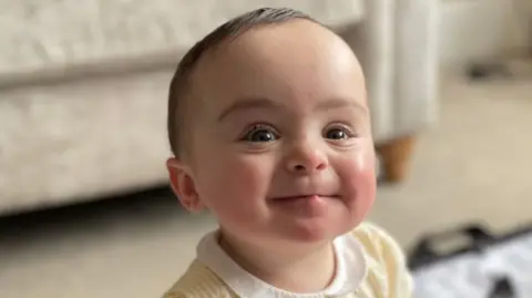 Family Handout Family photo of Genevieve Meehan. She is sitting up and smiling at the camera. She is wearing a yellow dress. 