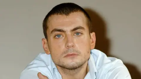 Getty Images Paul Danan looking serious in a white shirt