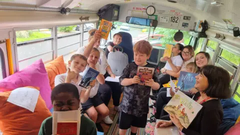 Imran Hafeez/Bradford Literacy Hub Children at Carrwood Primary in Homewood, Bradford are among 32 schools to have received new library facilities via the National Literacy Trust's campaign. They are pictured here aboard the Bradford Stories Bus.