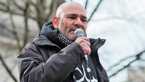 Abyd Quinn Aziz Abyd Quinn Aziz holding microphone