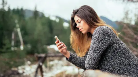 Getty Images Woman on phone in rural setting